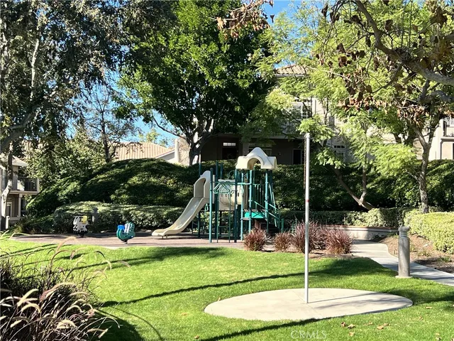 a view of a swimming pool with lawn chairs and plants