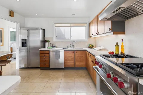 a kitchen with a stove top oven cabinets and a refrigerator