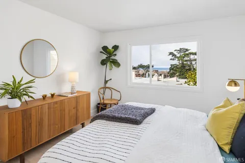 a bedroom with a bed and a potted plant