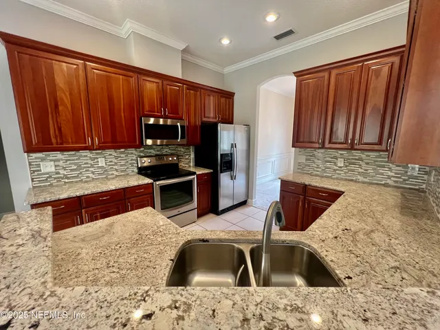 an empty room with windows fireplace and a ceiling fan