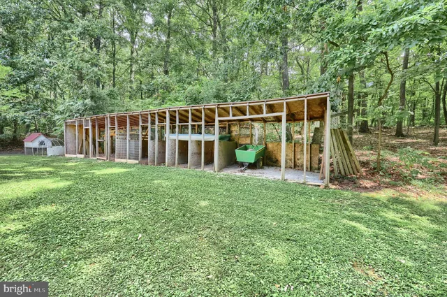 a view of a backyard with a table and chairs under an umbrella