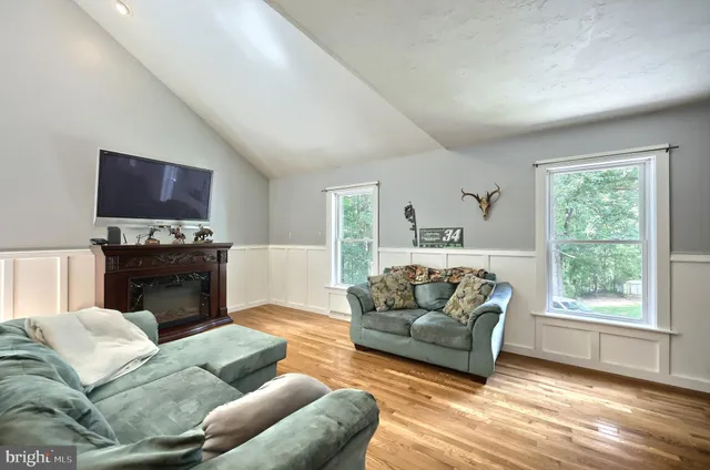 a living room with furniture kitchen view and a large window