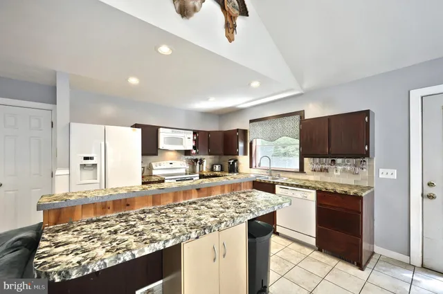 a kitchen with granite countertop a sink and a stove