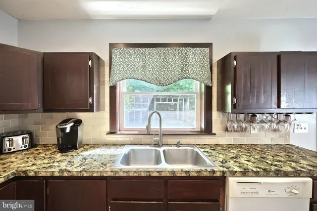 a kitchen with a stove top oven a sink a refrigerator and cabinets