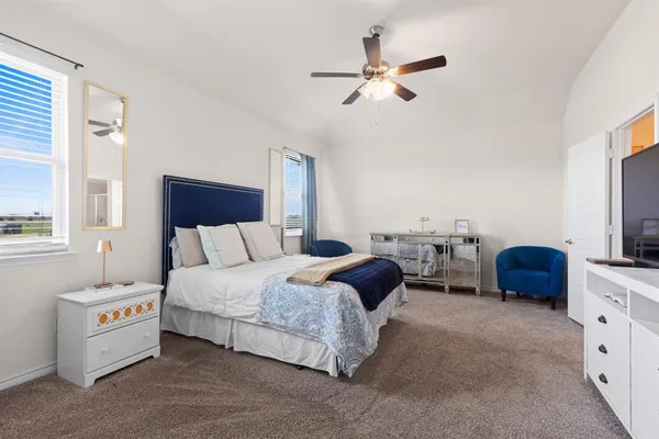 a spacious bedroom with a bed and a tv