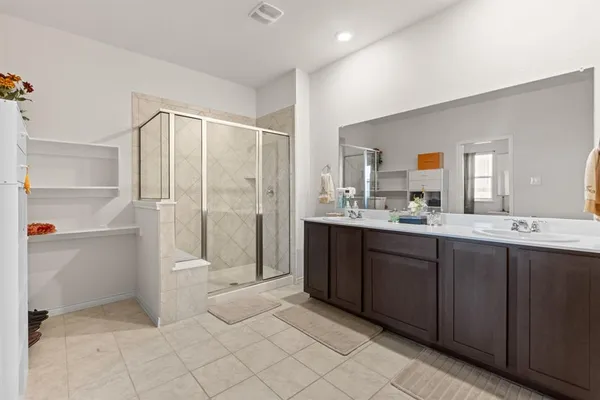a bathroom with a double vanity sink toilet and shower
