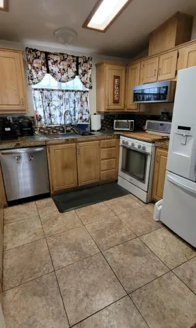 a kitchen with granite countertop a stove a sink and a microwave