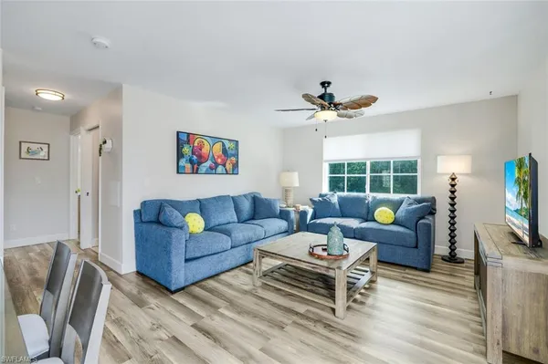 a living room with furniture a window and a flat screen tv