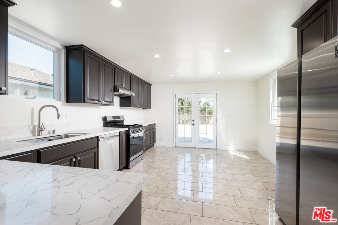 628 Silver Boulevard Los Angeles, CA 90026 - Photo 7 of 22 a large kitchen with stainless steel appliances granite countertop a sink refrigerator and cabinets