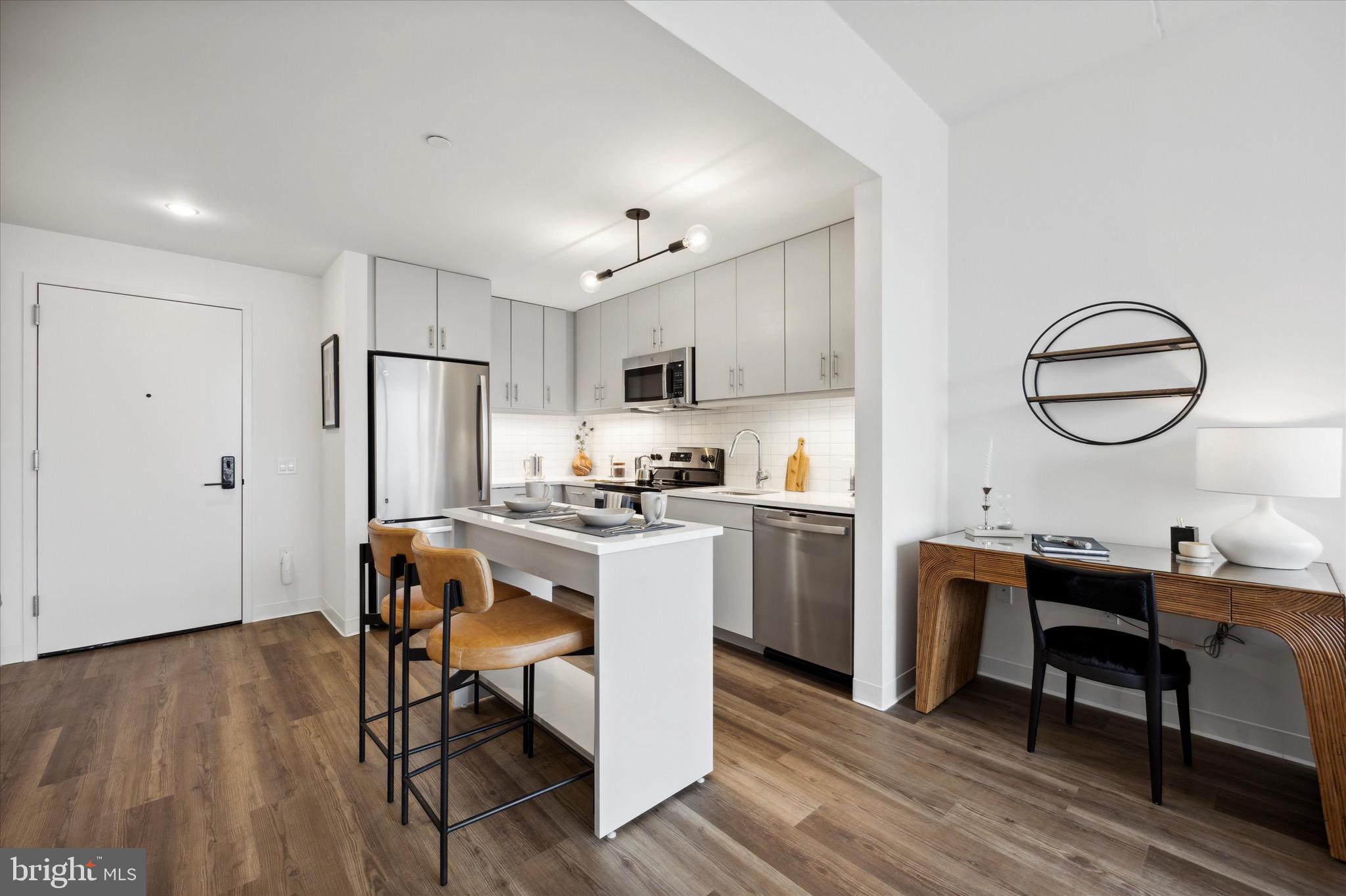 569 North 5th Street, Unit 830 Philadelphia, PA 19123 - Photo 3 of 46 a kitchen with a table chairs refrigerator and cabinets