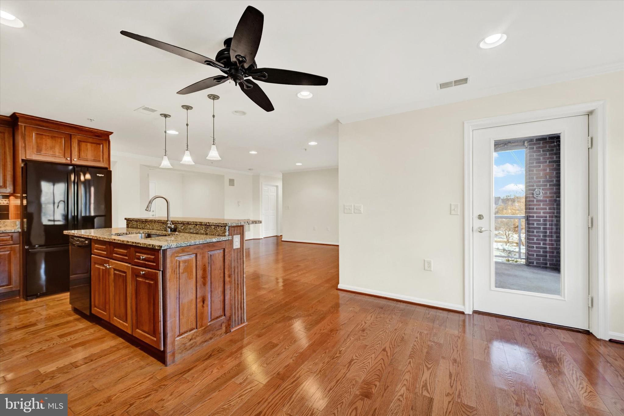 12236 Roundwood Road, Unit 104 Lutherville-Timonium, MD 21093 - Photo 12 of 27 a kitchen with stainless steel appliances granite countertop a stove and a wooden floors