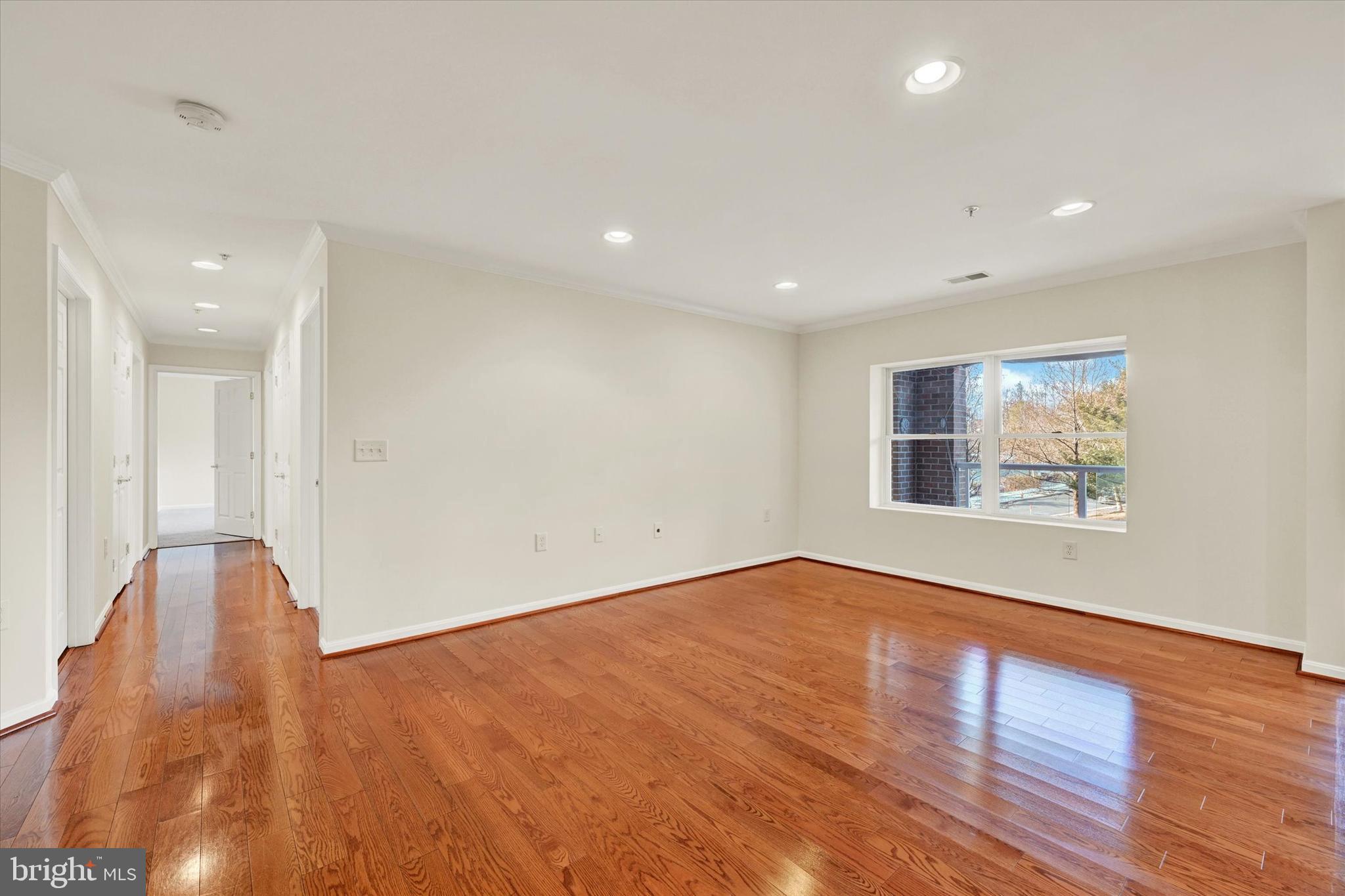 12236 Roundwood Road, Unit 104 Lutherville-Timonium, MD 21093 - Photo 14 of 27 a view of an empty room with wooden floor and a window