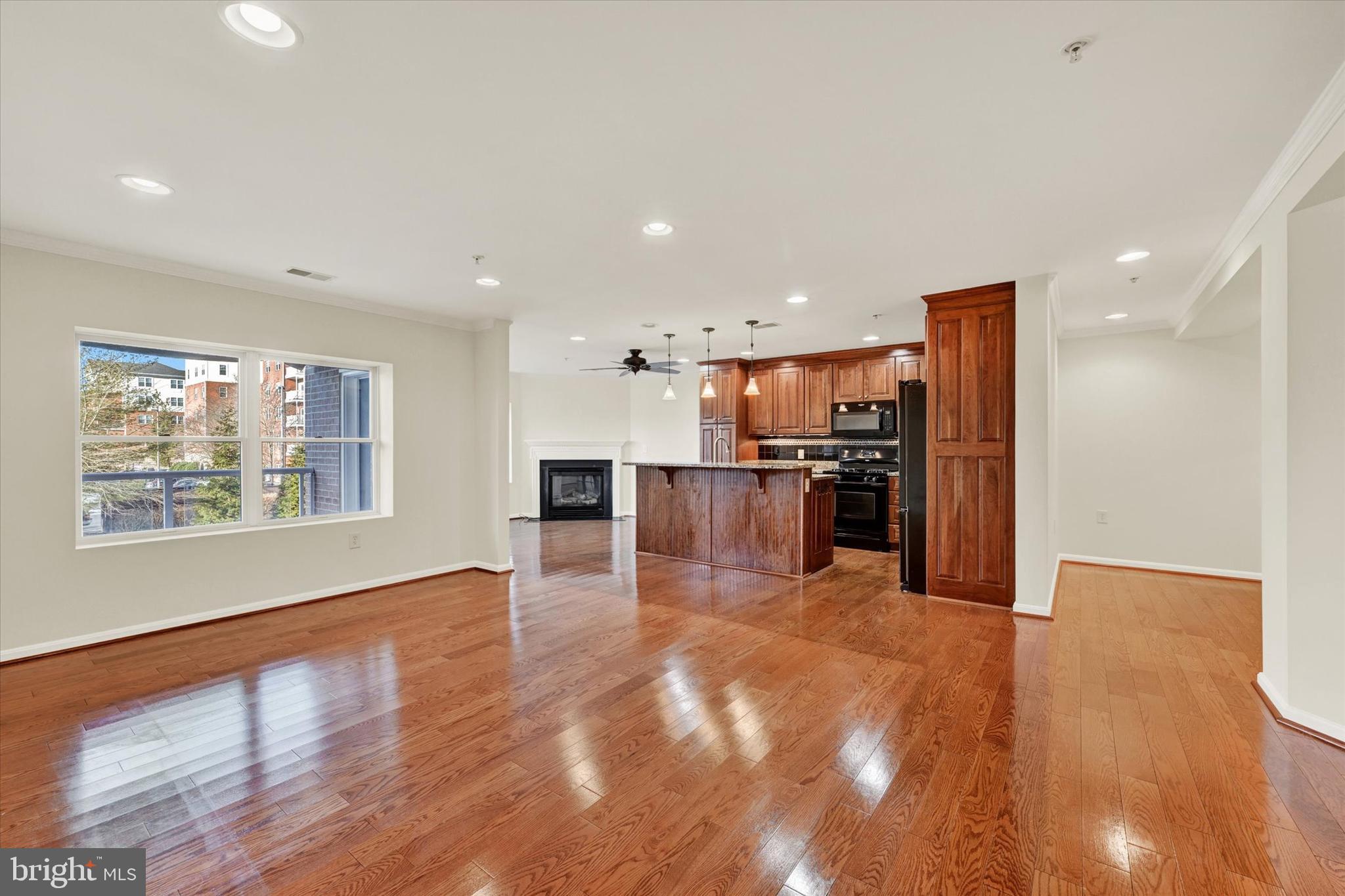 12236 Roundwood Road, Unit 104 Lutherville-Timonium, MD 21093 - Photo 15 of 27 a view of a kitchen with kitchen island wooden floors stainless steel appliances and a window