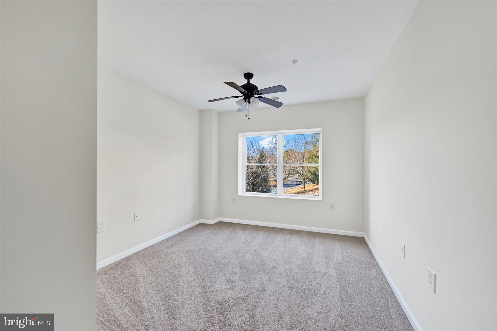 12236 Roundwood Road, Unit 104 Lutherville-Timonium, MD 21093 - Photo 19 of 27 an empty room with window and ceiling fan