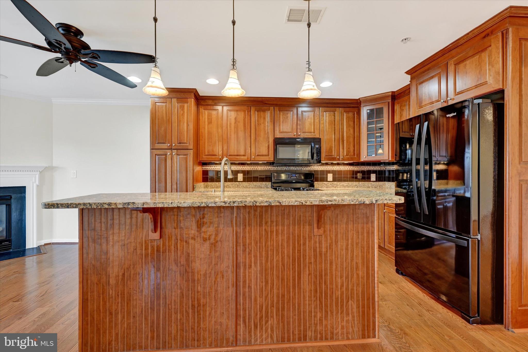 12236 Roundwood Road, Unit 104 Lutherville-Timonium, MD 21093 - Photo 7 of 27 a kitchen with stainless steel appliances a refrigerator a stove a sink and a wooden floors