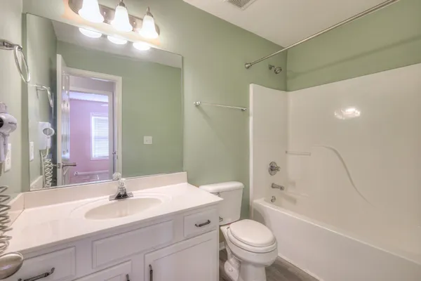 a bathroom with a sink a toilet and a large mirror