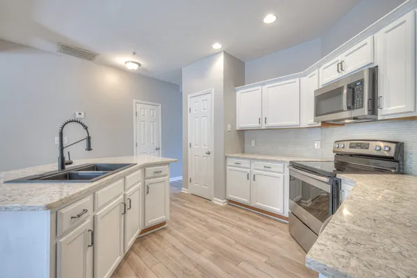 a kitchen with stainless steel appliances granite countertop a sink and stove top oven