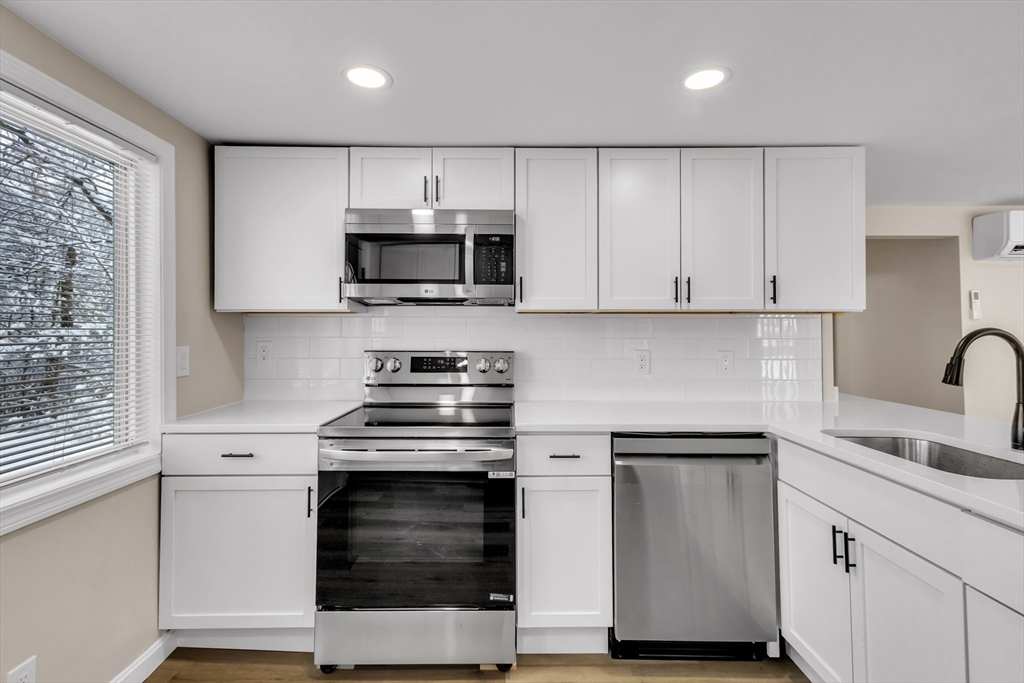 a kitchen with cabinets stainless steel appliances and sink