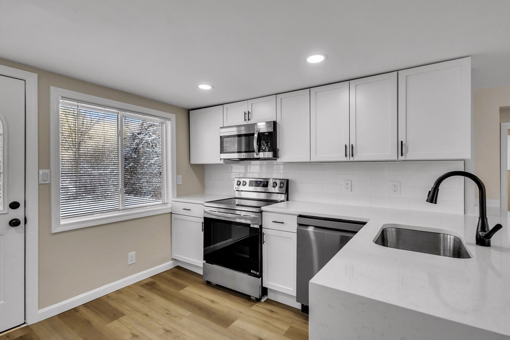 1 Columbia Road Billerica, MA 01821 - Photo 3 of 22 a kitchen with stainless steel appliances granite countertop a stove a sink and a microwave