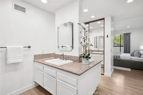a bathroom with a granite countertop sink and a mirror