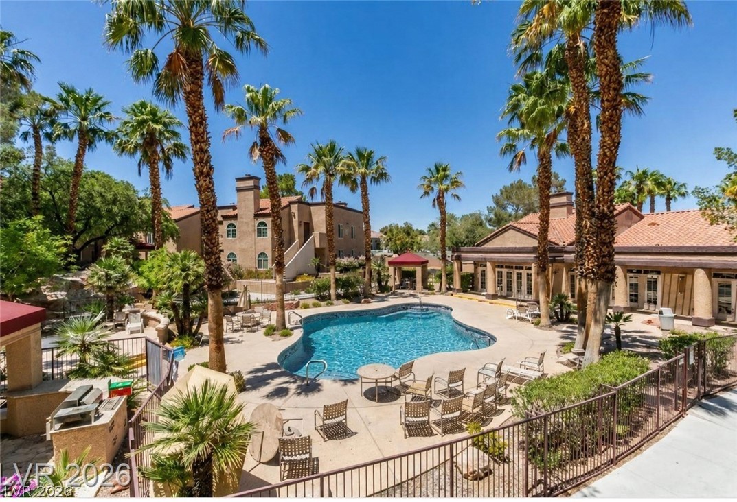 9325 West Desert Inn Road, Unit 244 Las Vegas, NV 89117 - Photo 36 of 55 An inviting community pool beckons, surrounded by tall palms and Mediterranean-style buildings.