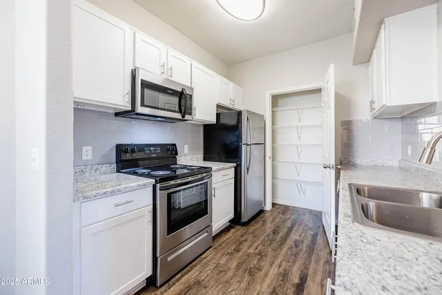 a kitchen with stainless steel appliances granite countertop a stove a microwave and a refrigerator