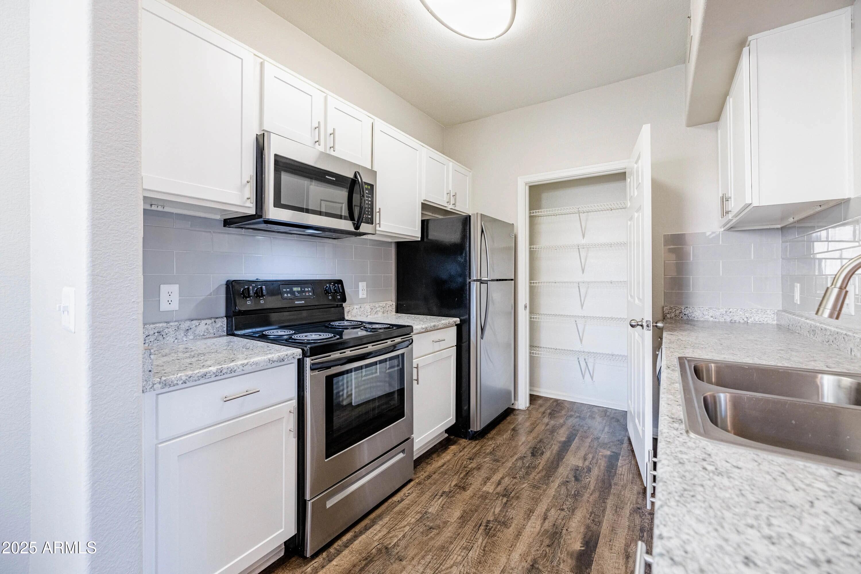 17374 North 89th Avenue, Unit C1 Peoria, AZ 85382 - Photo 2 of 22 a kitchen with stainless steel appliances granite countertop a stove a microwave and a refrigerator