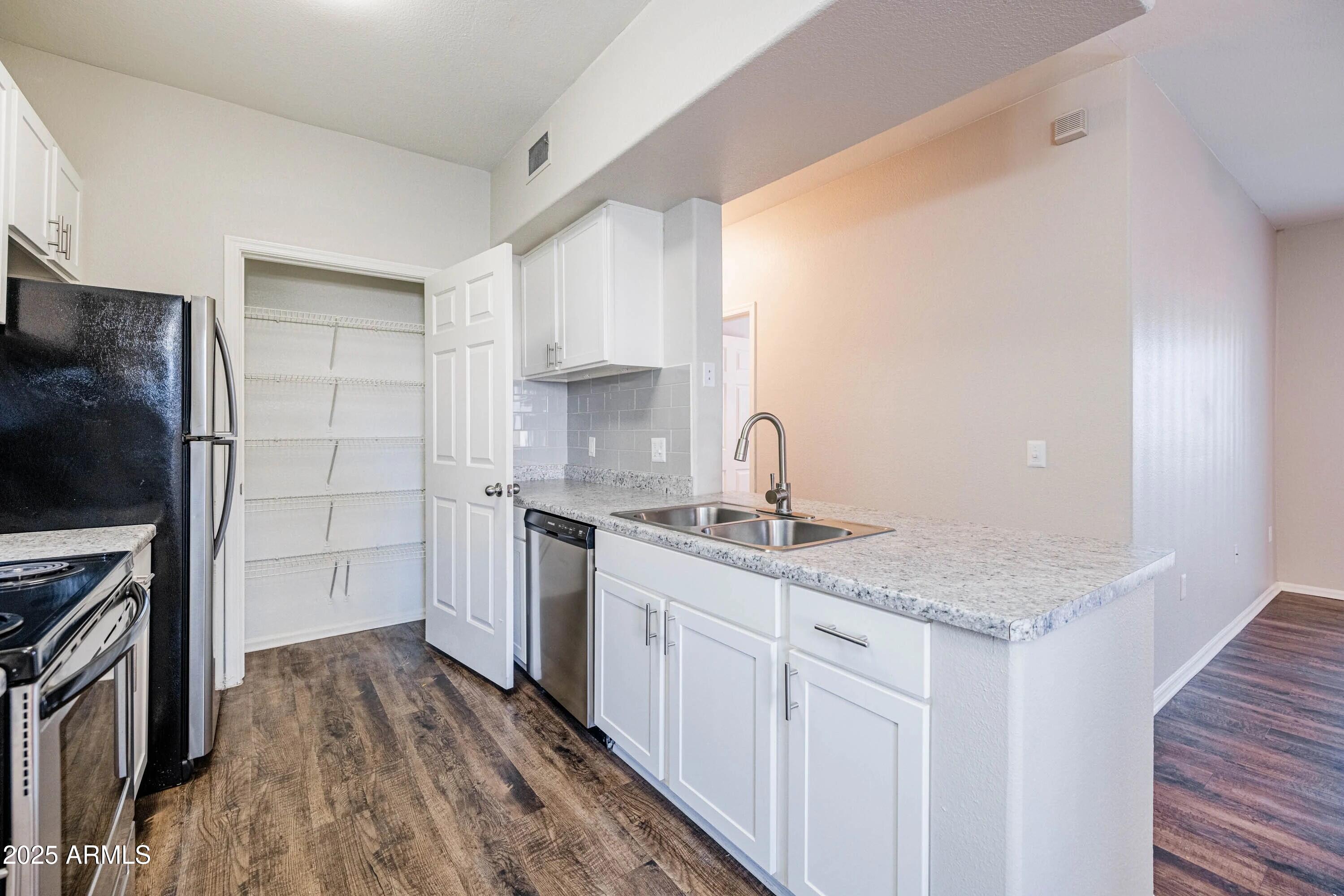 17374 North 89th Avenue, Unit C1 Peoria, AZ 85382 - Photo 3 of 22 a kitchen with a sink stove and refrigerator