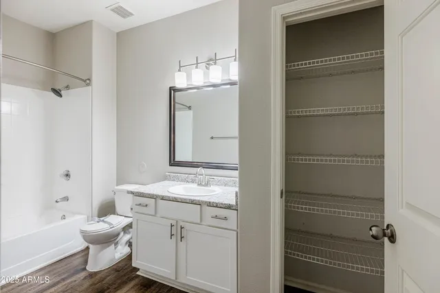 a bathroom with a granite countertop sink toilet a mirror and shower