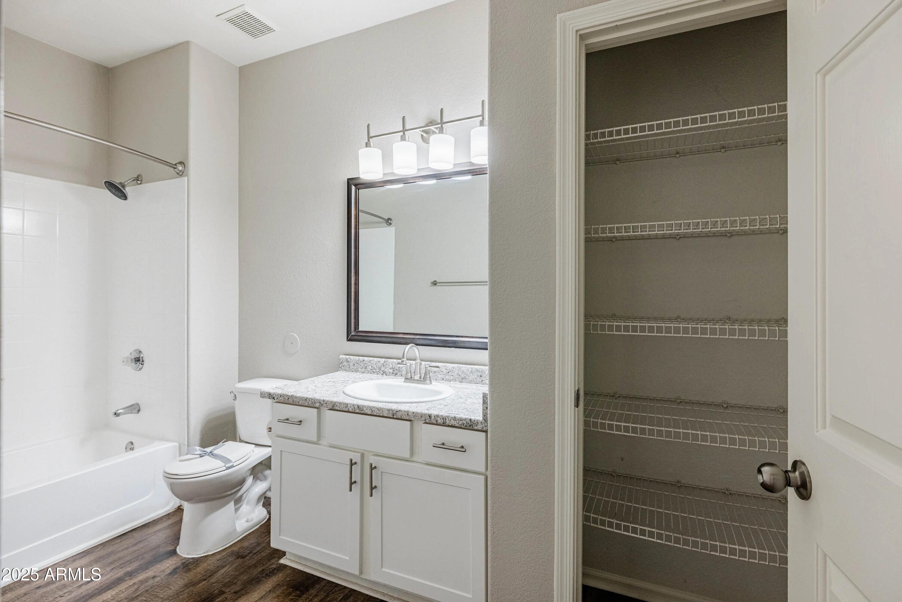 17374 North 89th Avenue, Unit C1 Peoria, AZ 85382 - Photo 5 of 22 a bathroom with a granite countertop sink toilet a mirror and shower
