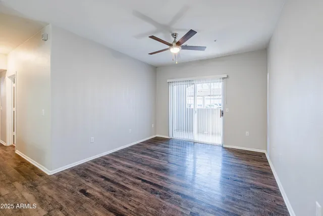 a view of an empty room with window and wooden floor
