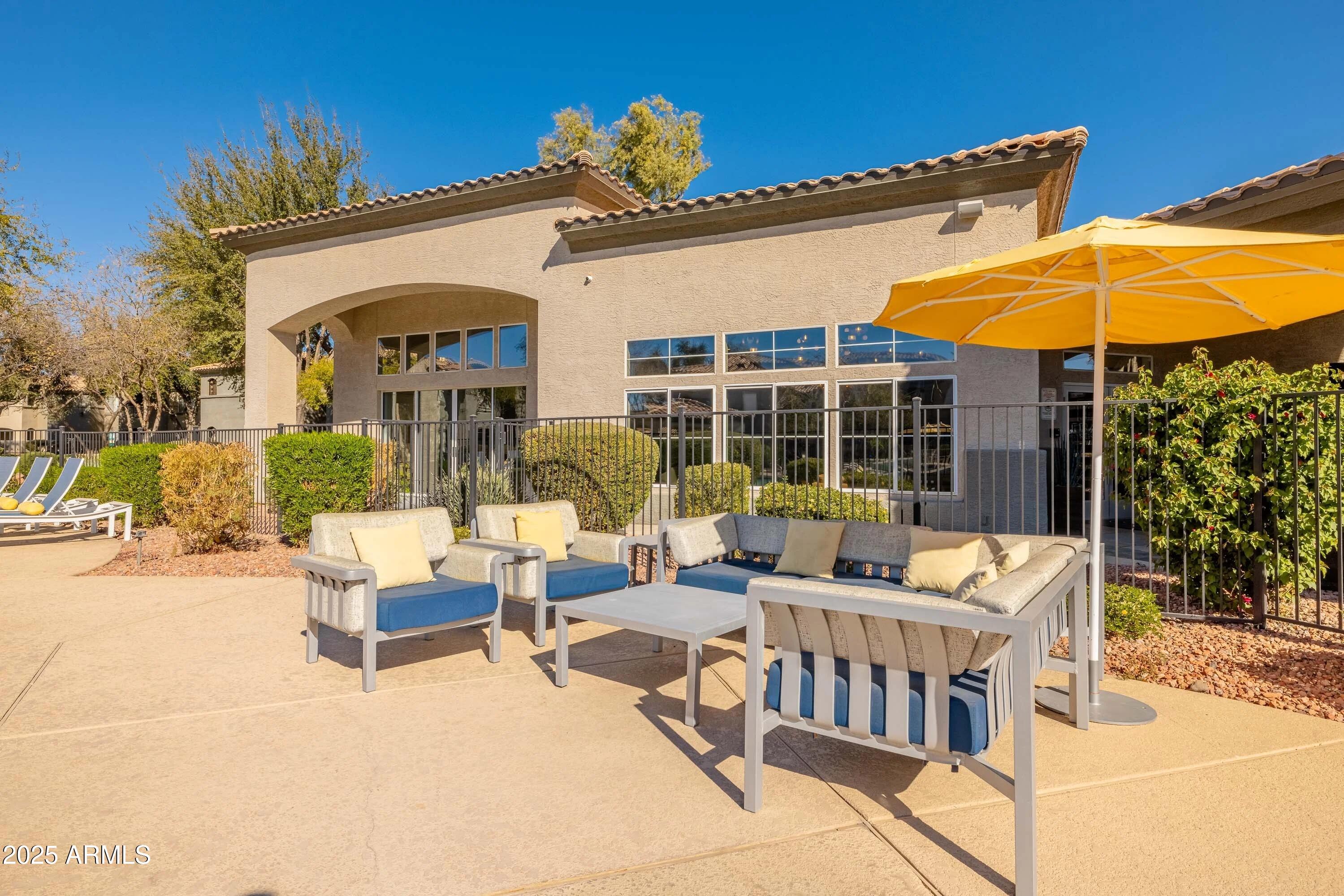 17374 North 89th Avenue, Unit C1 Peoria, AZ 85382 - Photo 10 of 22 a view of a patio with couches table and chairs under an umbrella