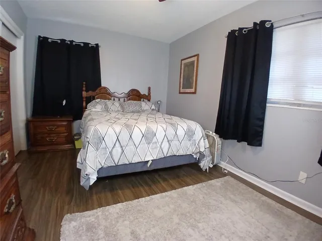 a bedroom with a bed window and dresser