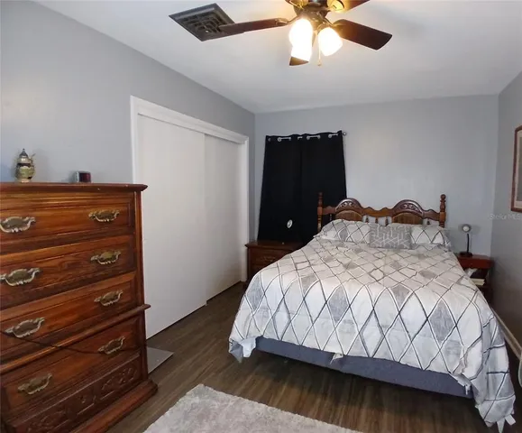 a bedroom with a bed and a ceiling fan