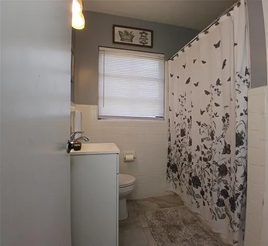 a bathroom with a toilet and a shower curtain