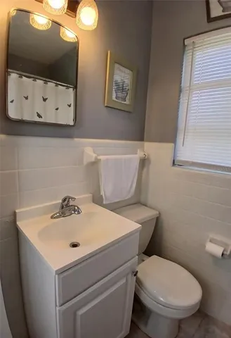 a bathroom with a sink a toilet and mirror