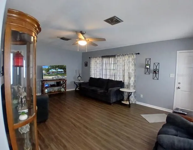 a living room with furniture and a wooden floor