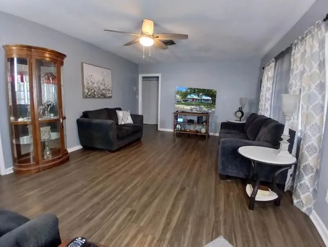 a living room with furniture and a wooden floor