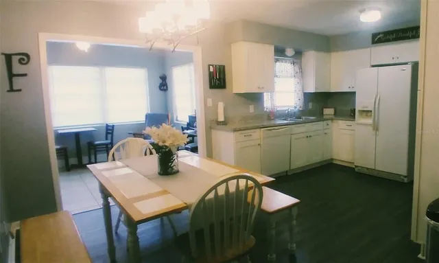 a kitchen with a table chairs and refrigerator