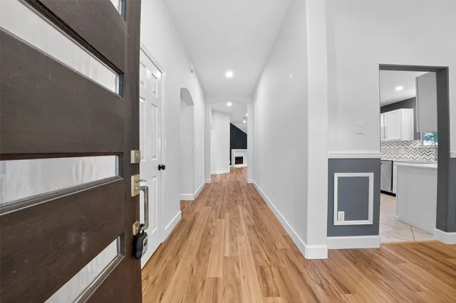 a view of a hallway with wooden floor and staircase