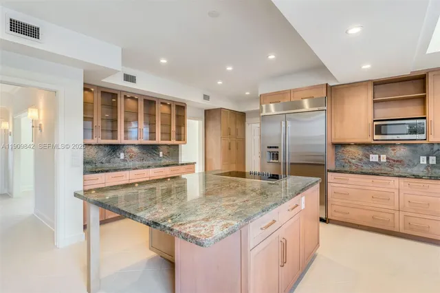 a kitchen with stainless steel appliances granite countertop a granite counter tops and a refrigerator