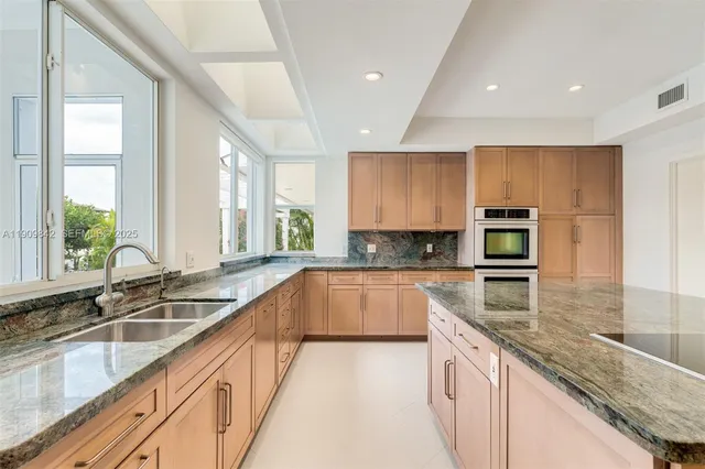 a kitchen with a sink a counter top space cabinets and stainless steel appliances