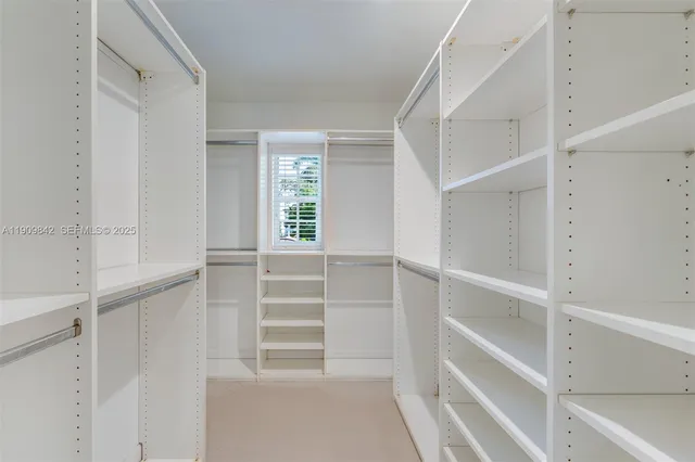 a view of walk in closet with empty racks