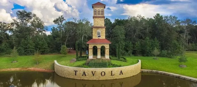 a view of a white house with a yard potted plants and large trees