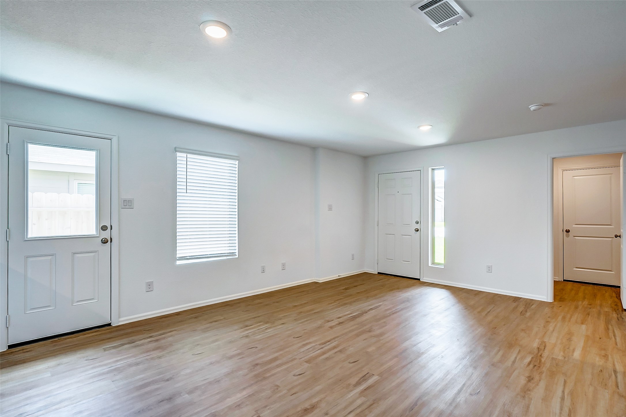 20961 Zuccala Drive New Caney, TX 77357 - Photo 7 of 33 an empty room with wooden floor and windows