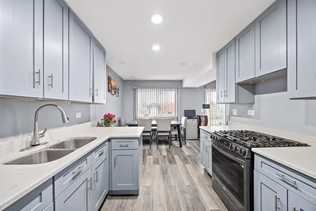 a kitchen with sink a stove and cabinets