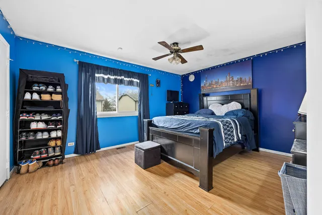 a bedroom with a large bed wooden floor and window