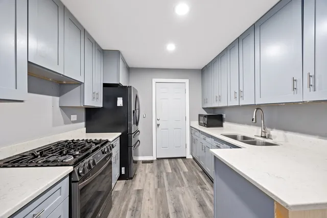 a kitchen with a sink stove top oven and cabinets