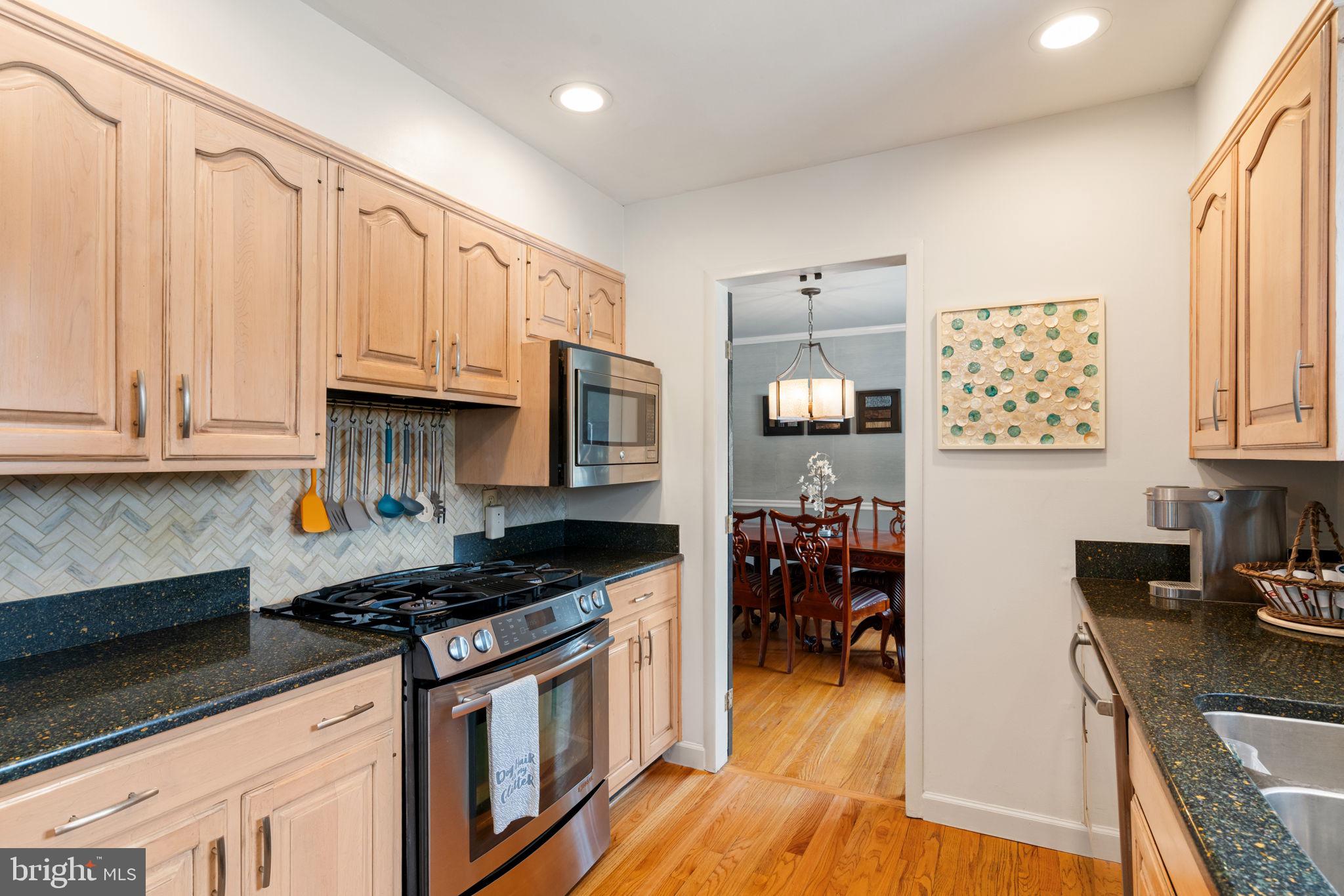 6102 Sherborn Lane Springfield, VA 22152 - Photo 16 of 51 a kitchen with stainless steel appliances granite countertop a stove top oven a sink dishwasher and cabinets with wooden floor