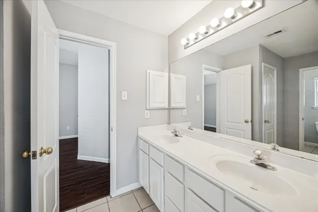 a bathroom with a double vanity sink and a mirror